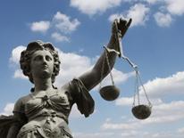 Legal Services for Seniors - statue of justice holding a scale, against a blue sky with clouds